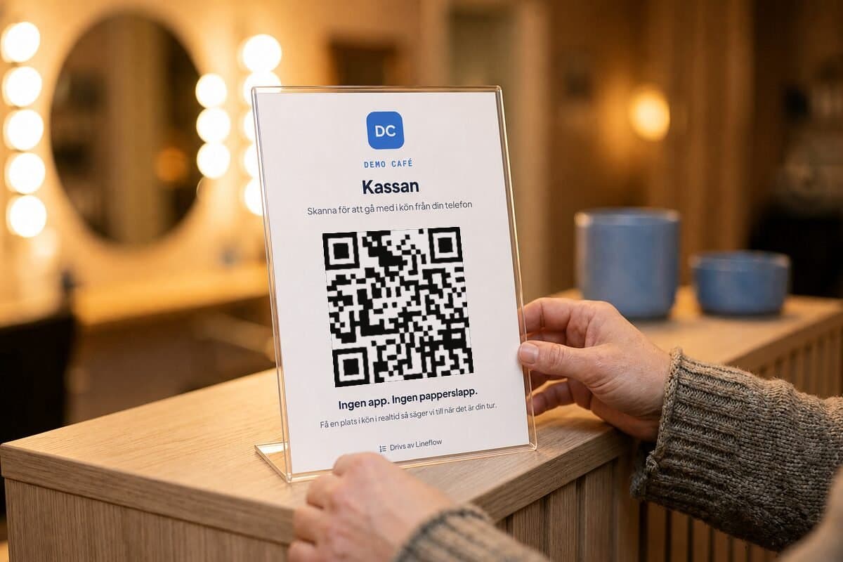 En utskriven QR-affisch för kön Kassan står i ett ställ på disken
